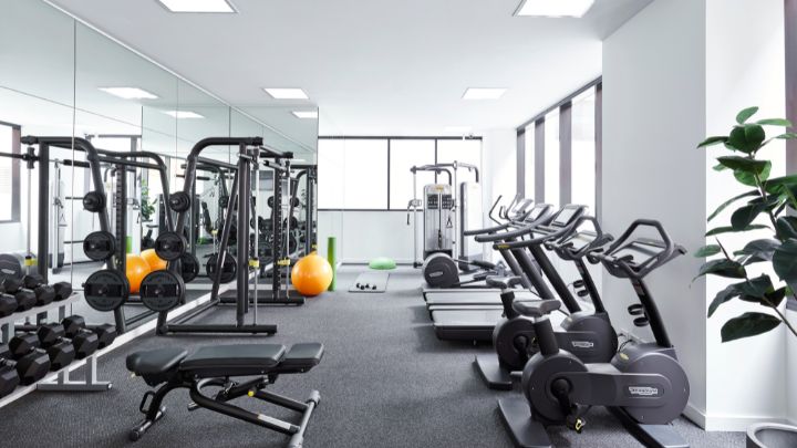 A gymnasium with rows of cardio and weights equipment